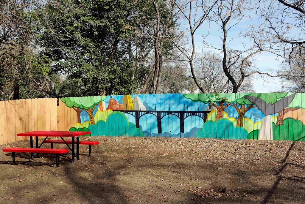 a red picnic table in front of a graffiti wall