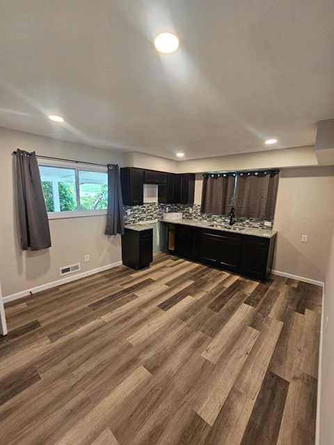 A room with wooden flooring and a kitchen island.
