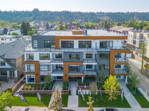 A modern apartment complex with a green lawn in front.