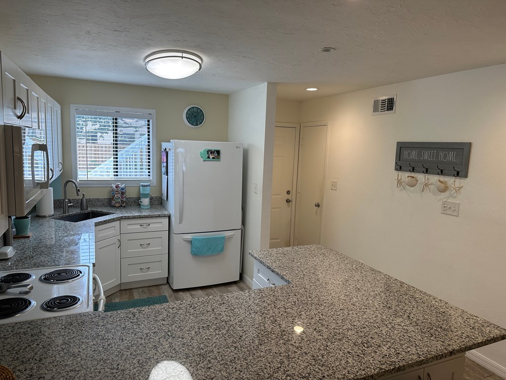 a kitchen with granite counter tops and a white refrigerator