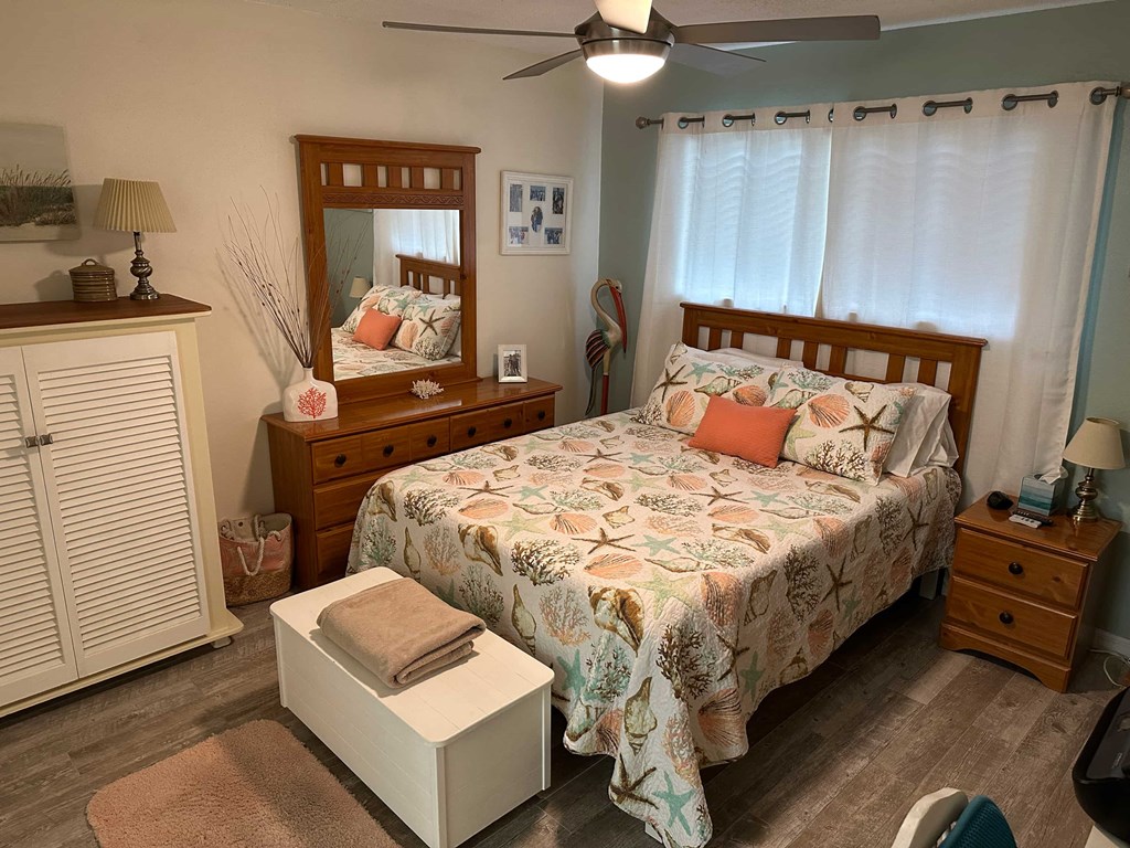 a bedroom with a bed and a dresser and a ceiling fan