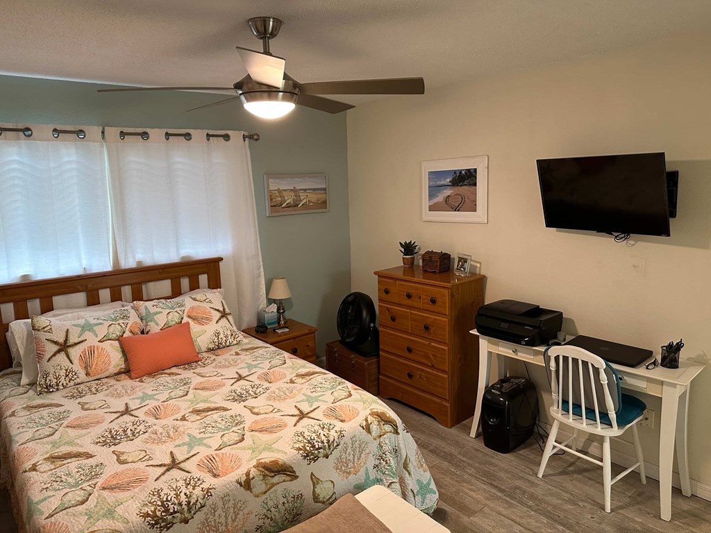 a bedroom with a bed and a desk and a tv