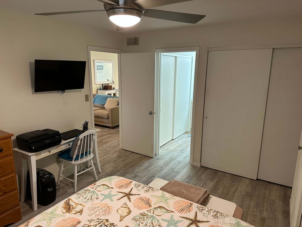 a bedroom with a bed and a desk and a tv