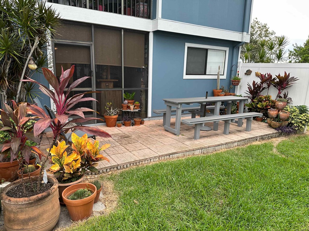 a patio with a picnic table in front of a house