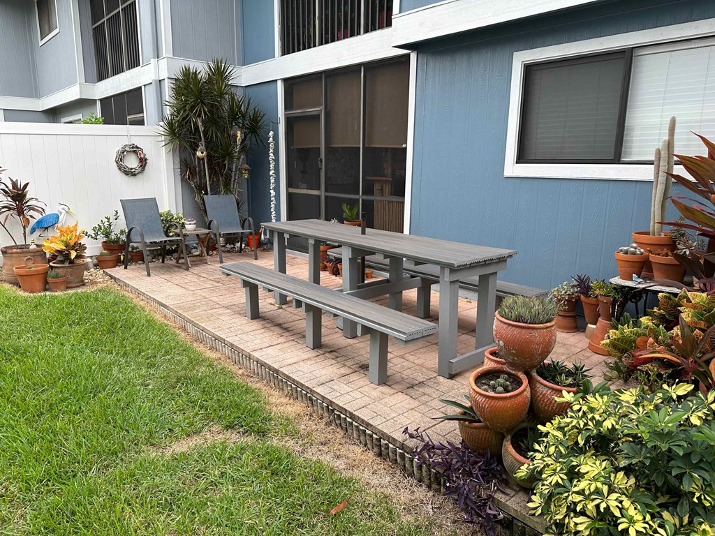 a patio with a table and chairs in a backyard