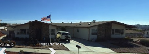 A house with a garage and a car parked in front.