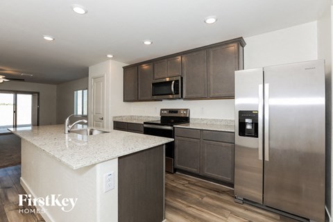 an updated kitchen with stainless steel appliances and granite counter tops