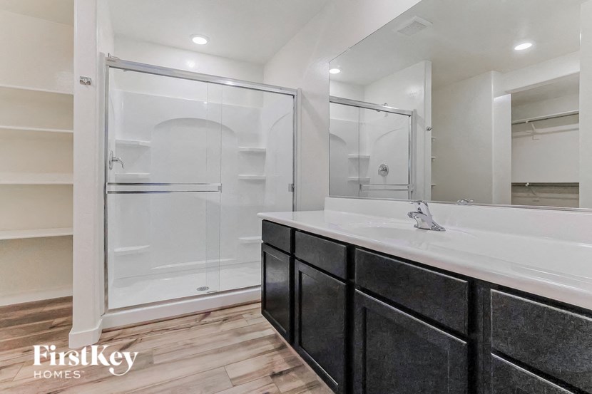 a bathroom with a large shower and a sink and a mirror
