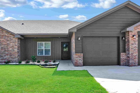 a home with a garage door and a lawn