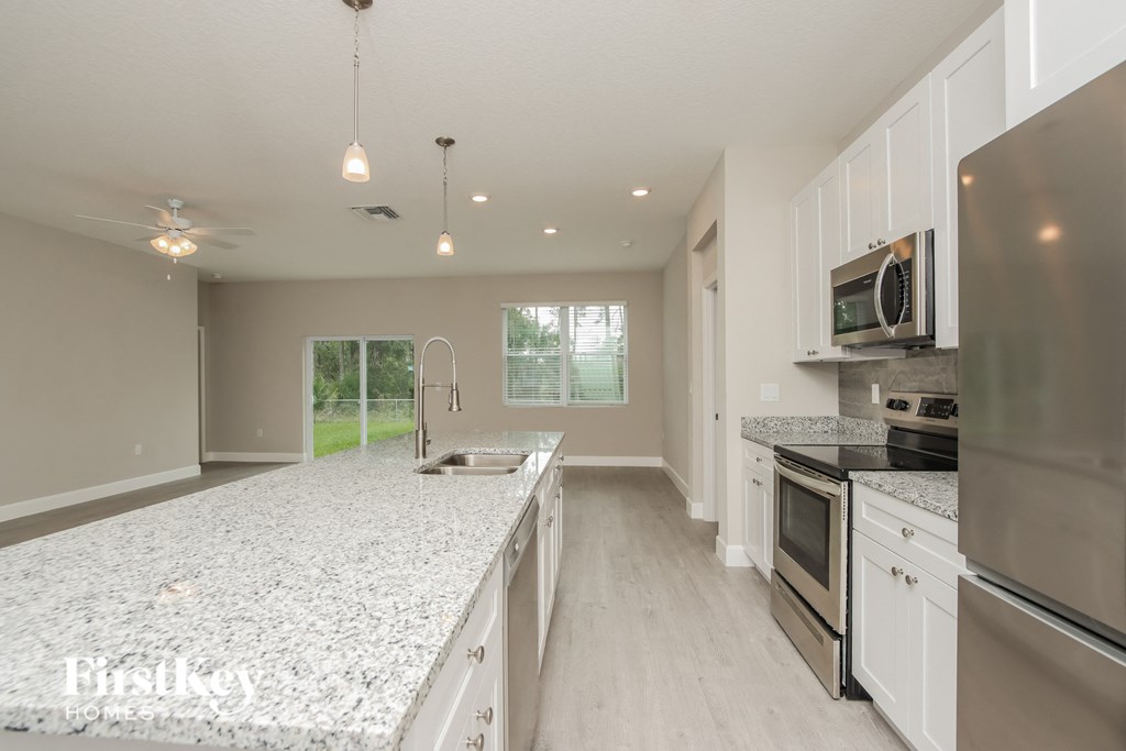 a large kitchen with granite counter tops and stainless steel appliances
