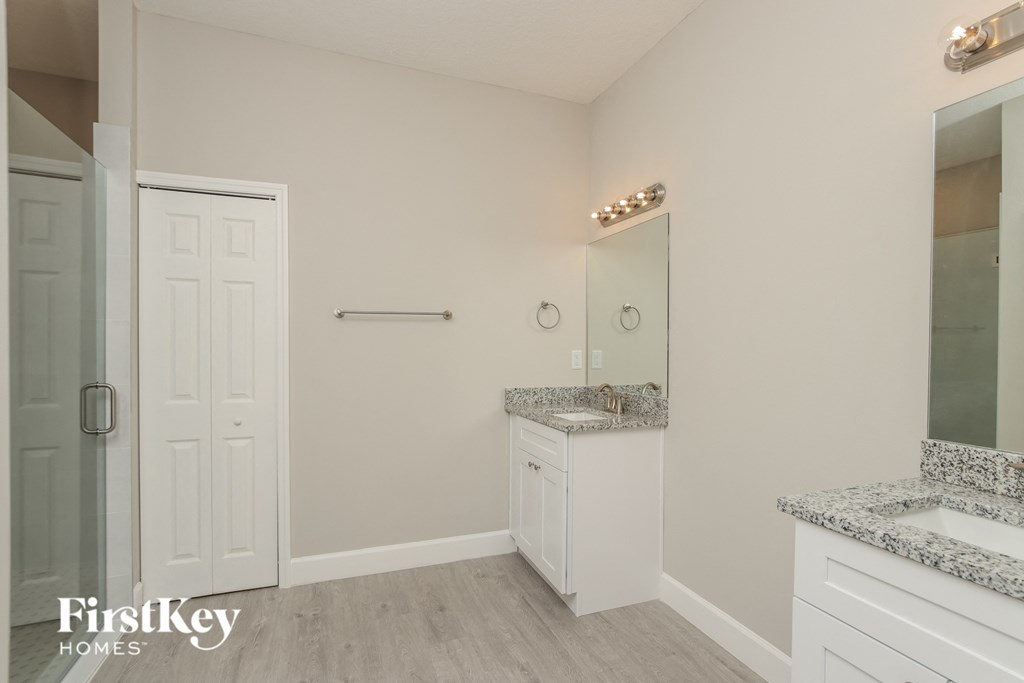 a bathroom with a sink and a mirror and a closet