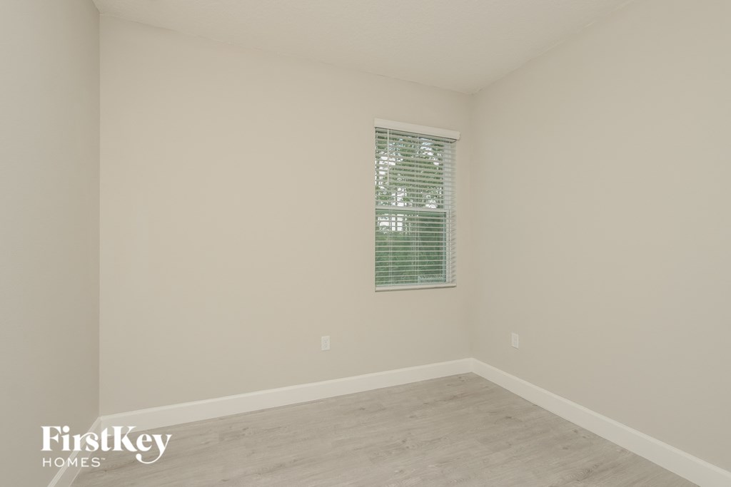 a room with white walls and a window and a wooden floor