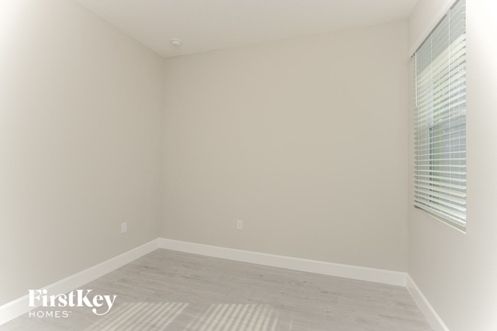 an empty room with white walls and a window