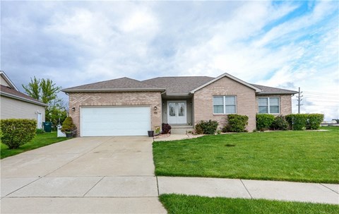 a brick house with a white garage door and a lawn