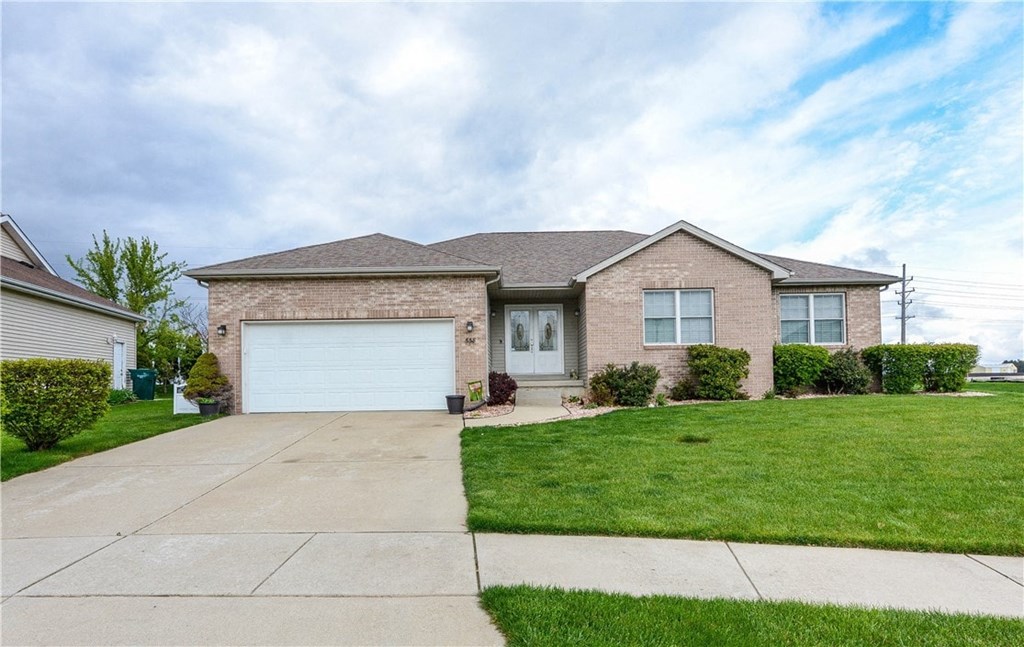 a brick house with a white garage door and a lawn