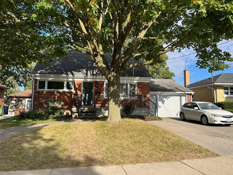 a red brick house with a tree in the front