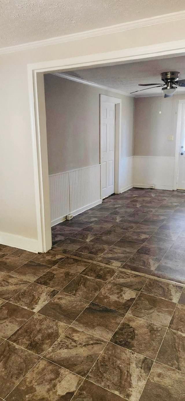 an empty living room with tile floors and a ceiling fan