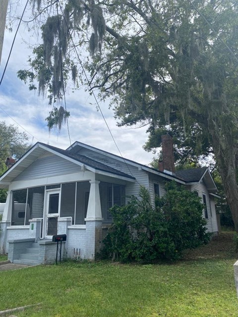 a white house with a tree in front of it