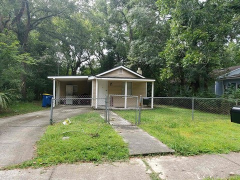 a small house with a fence in front of it