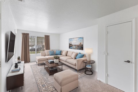 A living room with a couch, a chair, a coffee table, and a painting on the wall.