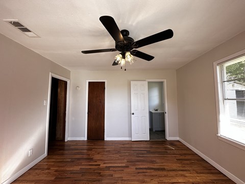 a living room with a ceiling fan and a closet