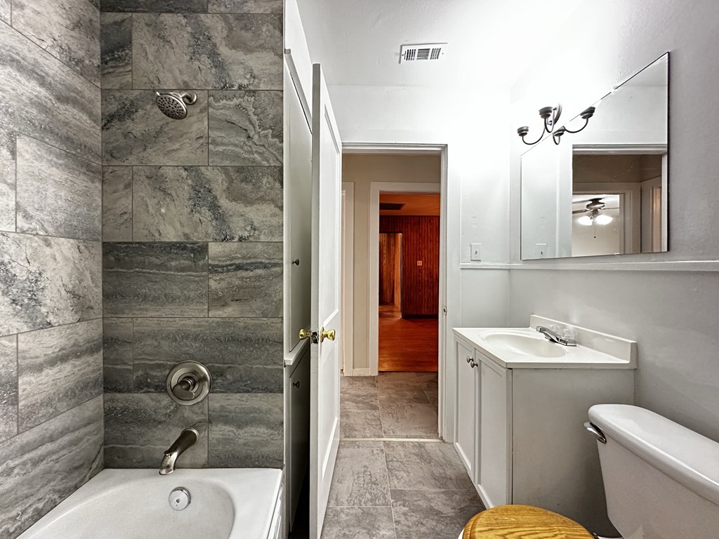 a bathroom with a tub and a sink and a mirror