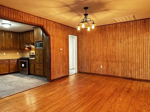 a kitchen and living room with wooden walls and wood flooring