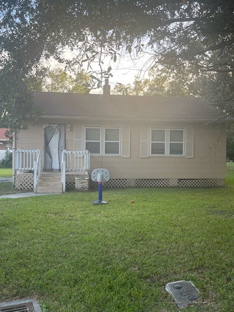 a house with two white rocking chairs in the yard