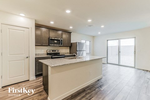 a kitchen with an island and a stainless steel refrigerator