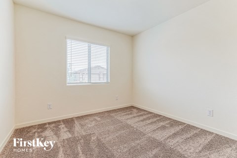a bedroom with carpet and a window