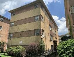 a tall brick building with a courtyard in front of it