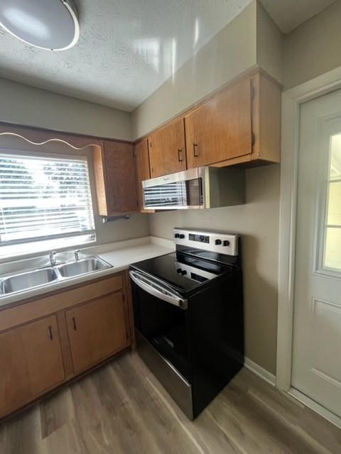 A kitchen with wooden cabinets and a black stove top oven.
