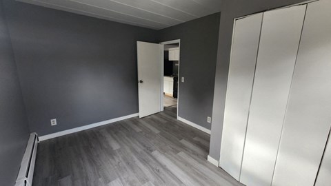 A room with a grey wall and a white door.