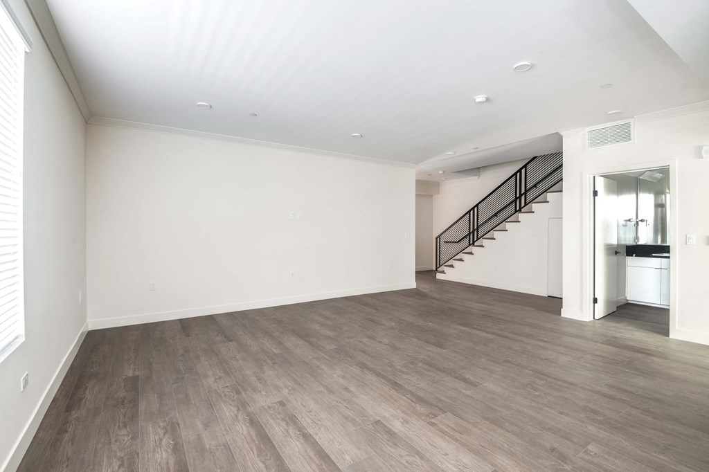 an empty living room with white walls and wood flooring