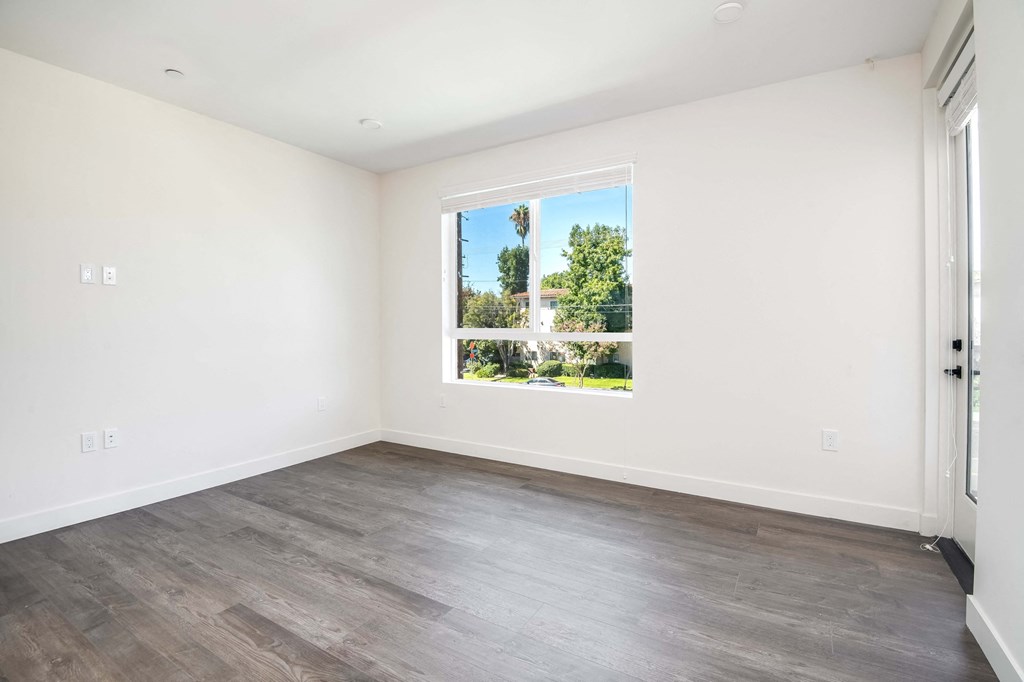 a living room with white walls and a window