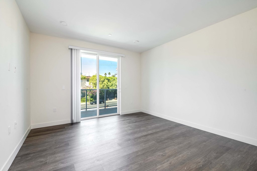 a living room with white walls and a sliding glass door