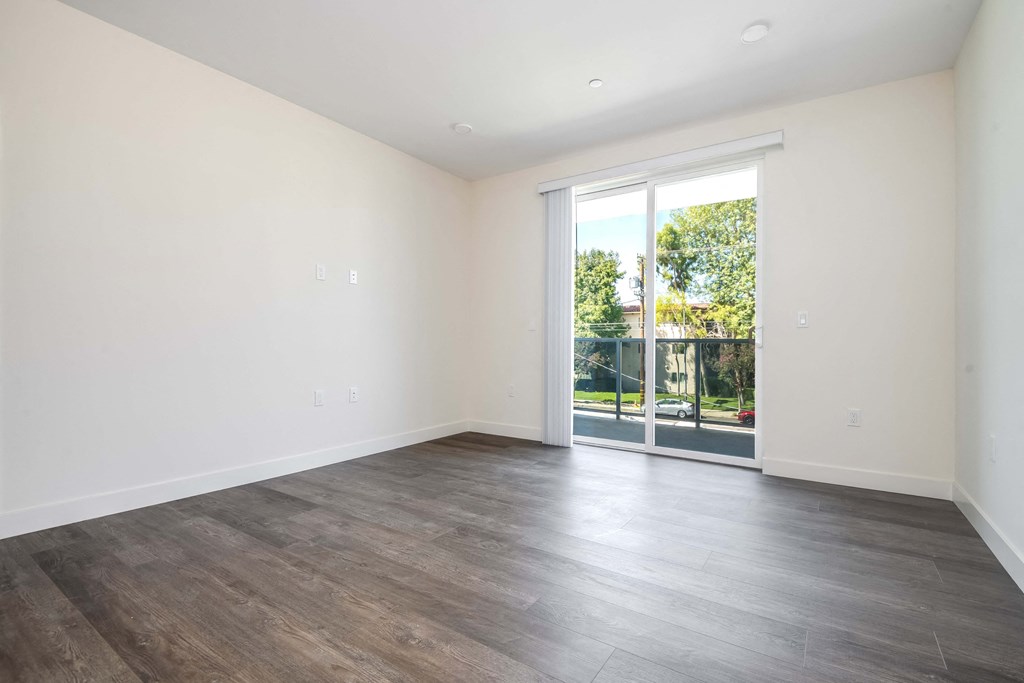 a living room with white walls and a sliding glass door