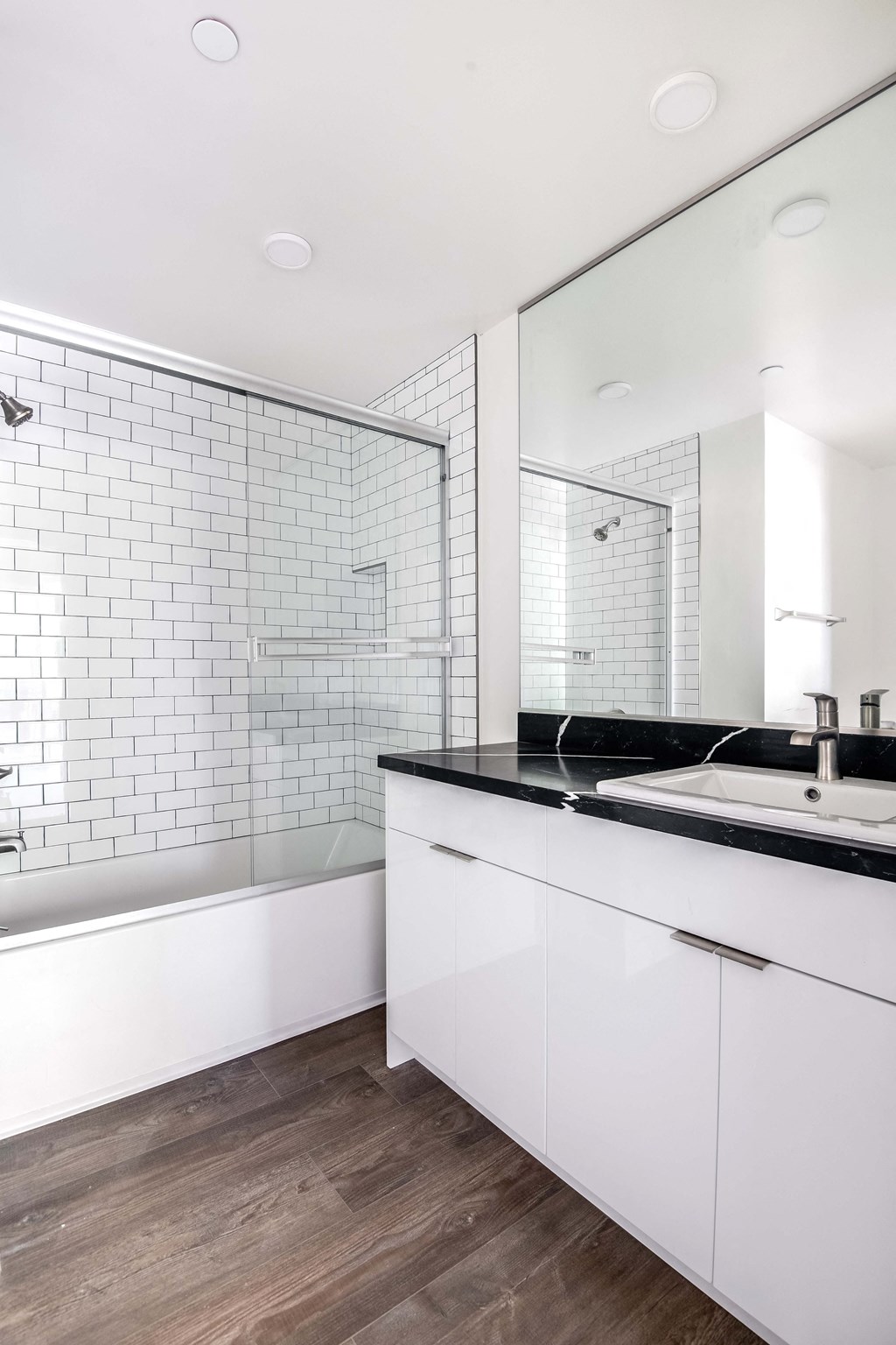 a white and black bathroom with a tub and a sink