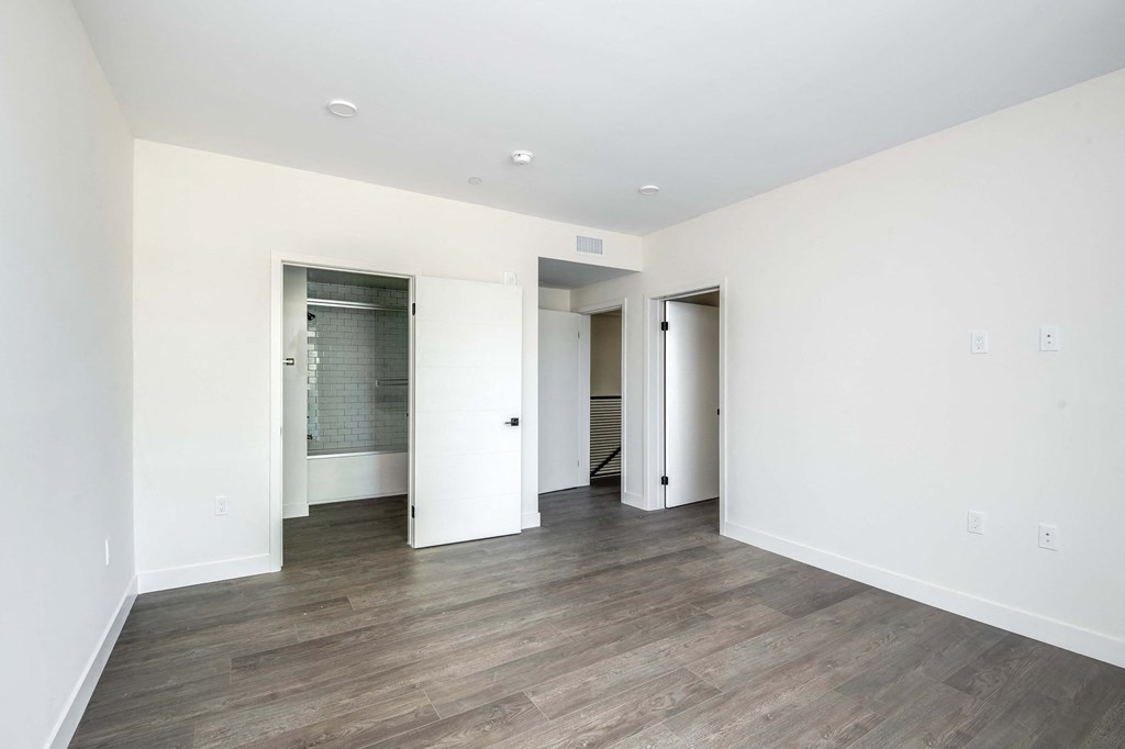 a living room with white walls and a hard wood floor