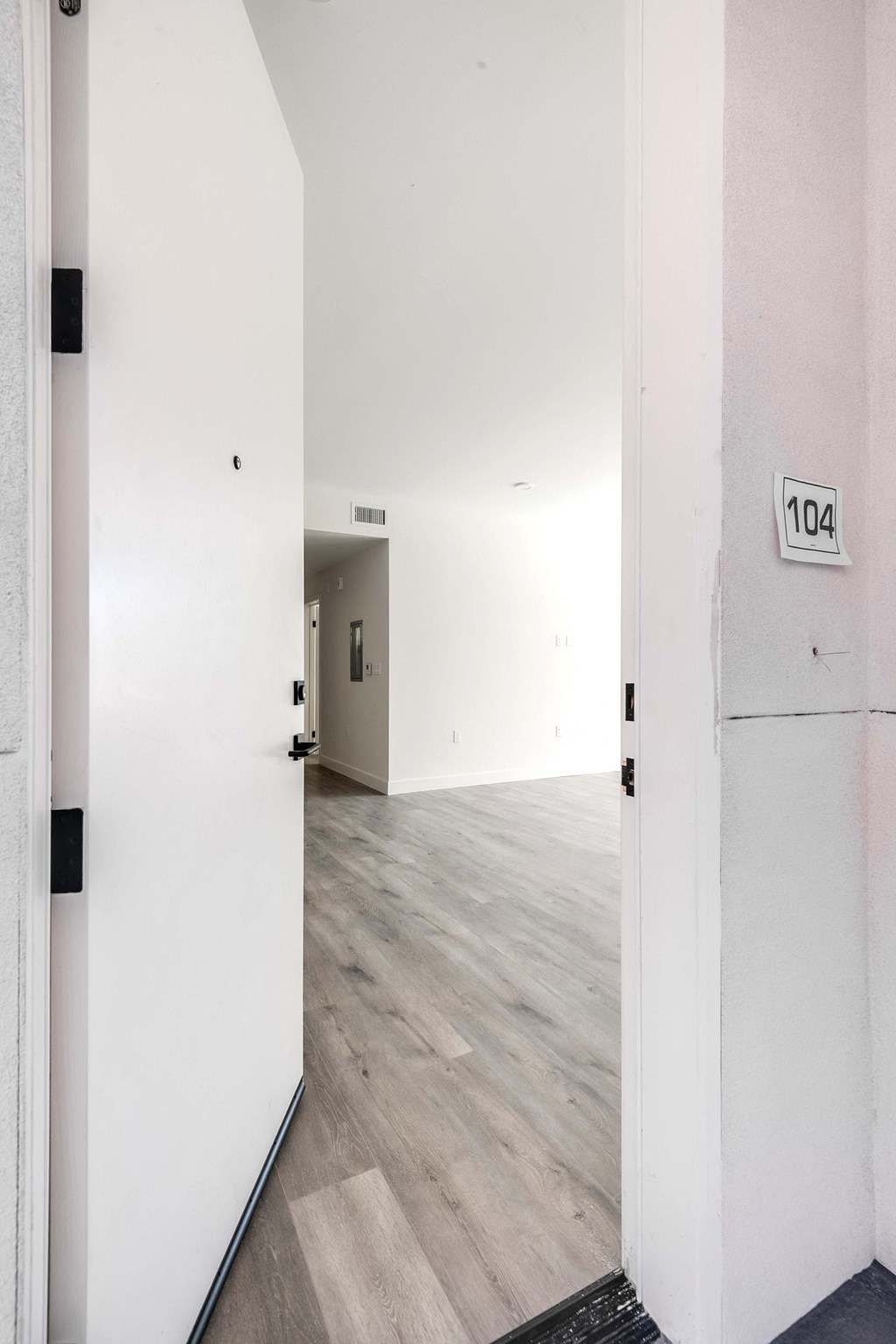 a white room with white walls and wood floors