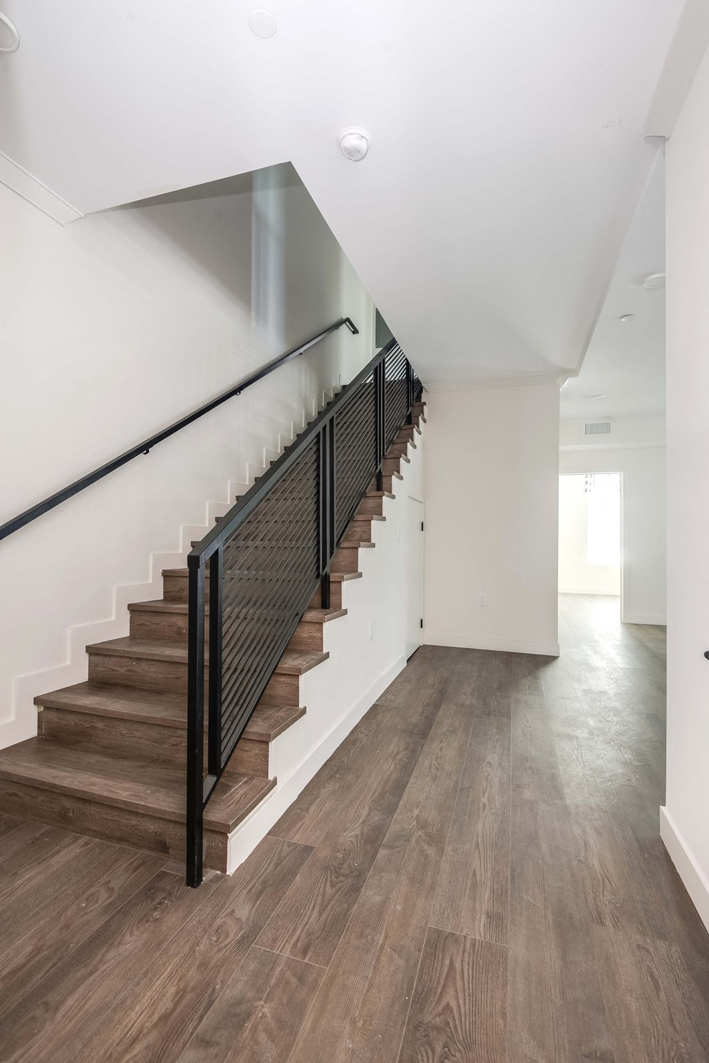 a view of a staircase in a home with wood floors and white walls