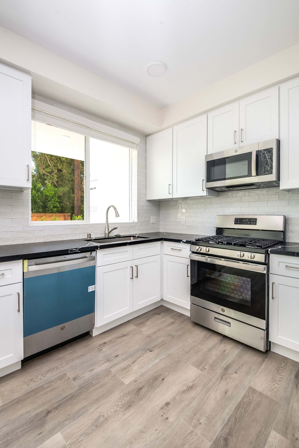 a kitchen with white cabinets and stainless steel appliances