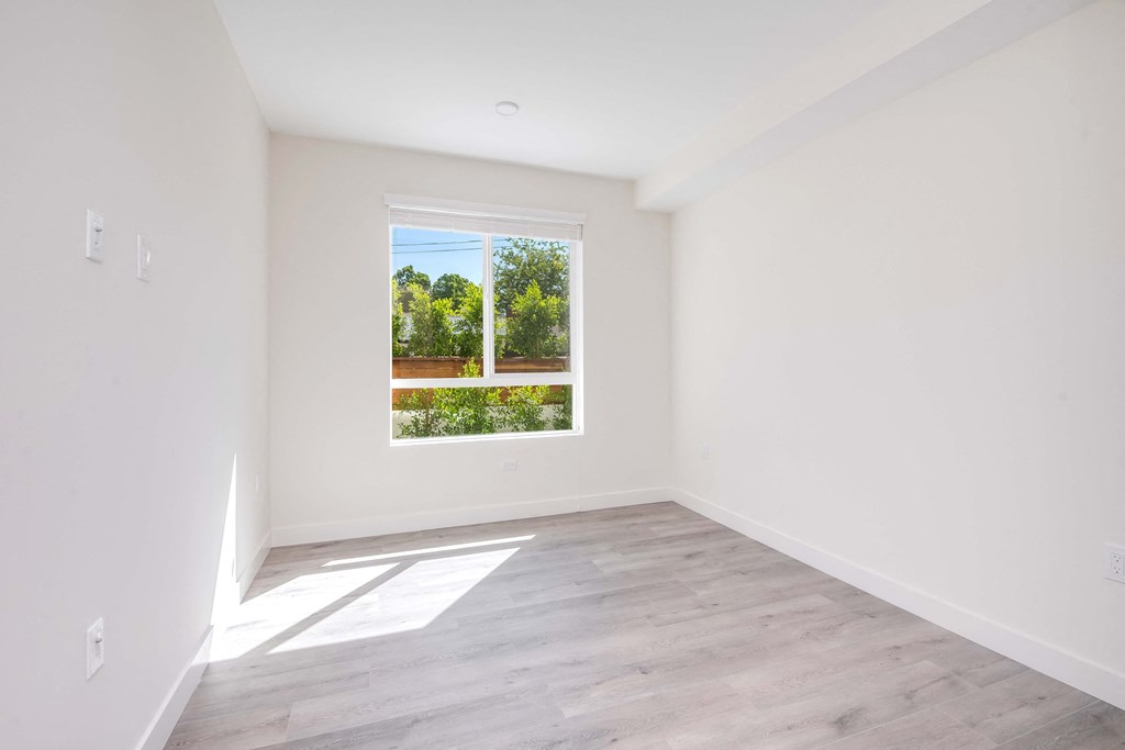 an empty room with white walls and a window