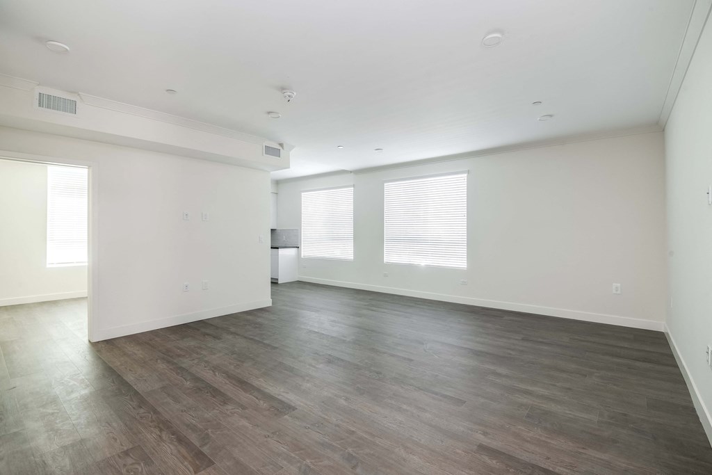 an empty living room with white walls and wood floors