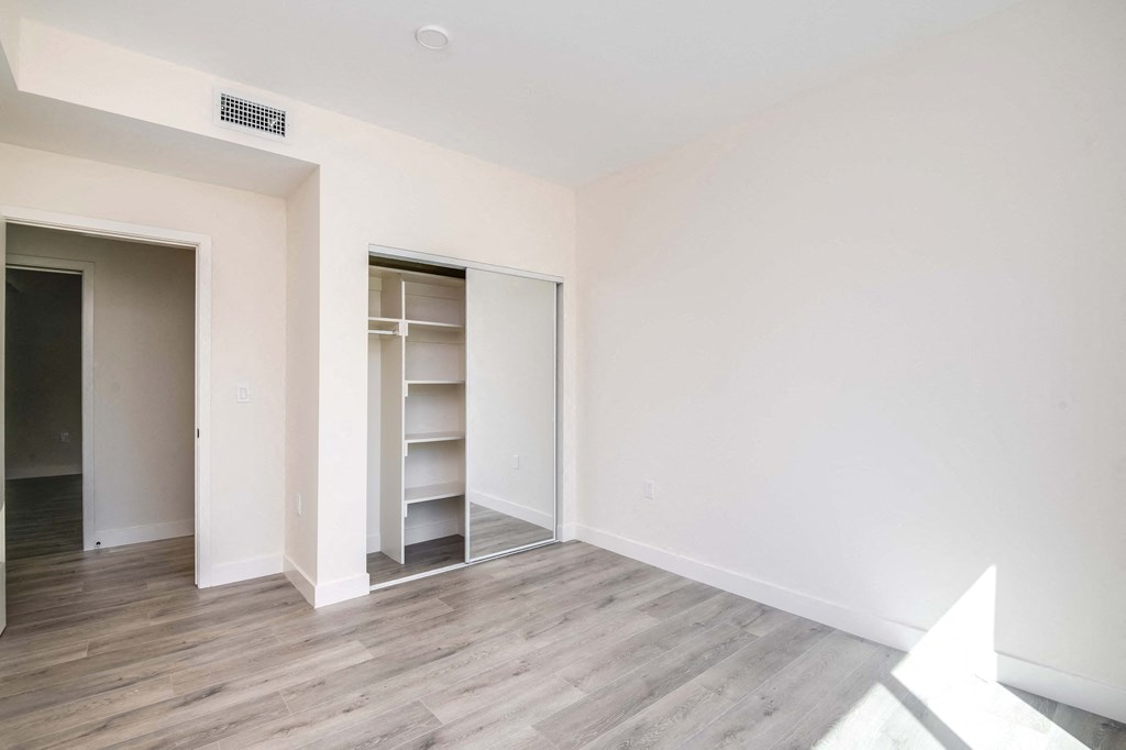 an empty room with white walls and a closet