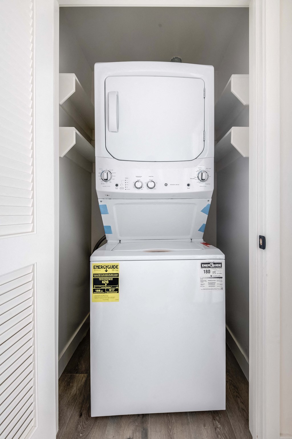 a white washer and dryer in a room with a door open