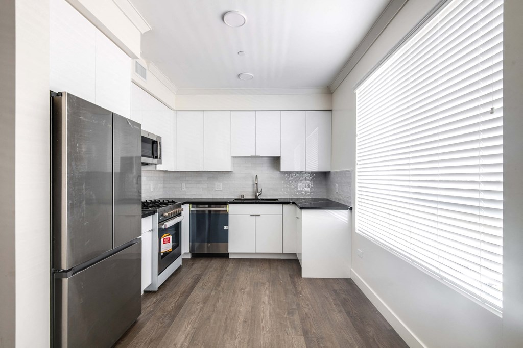 a kitchen with white cabinets and stainless steel appliances