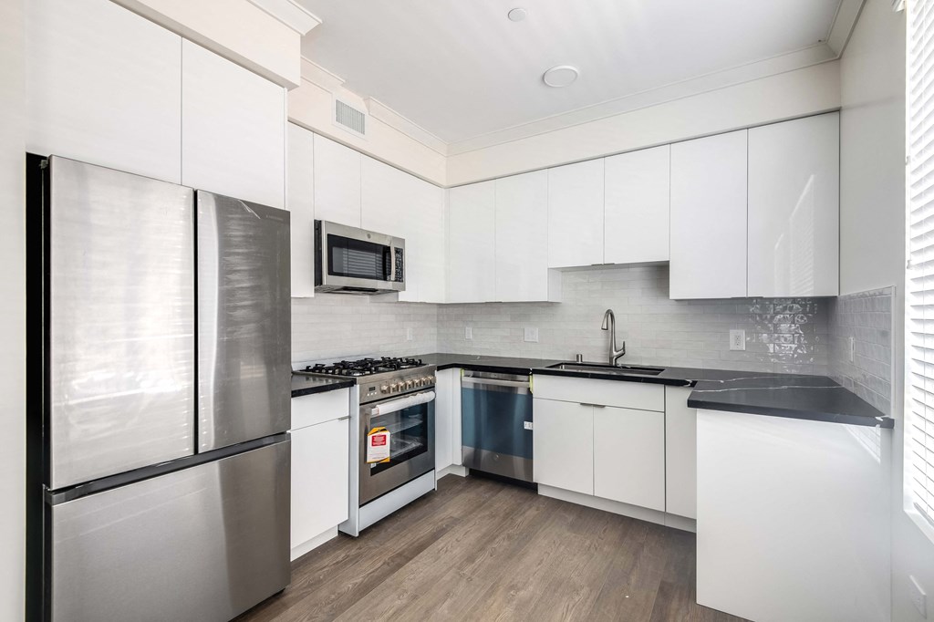 a kitchen with white cabinets and stainless steel appliances