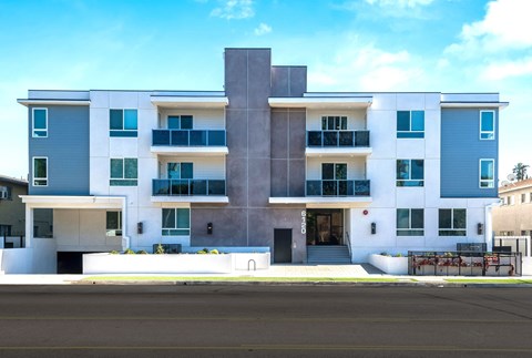a white and blue building with a street in front of it