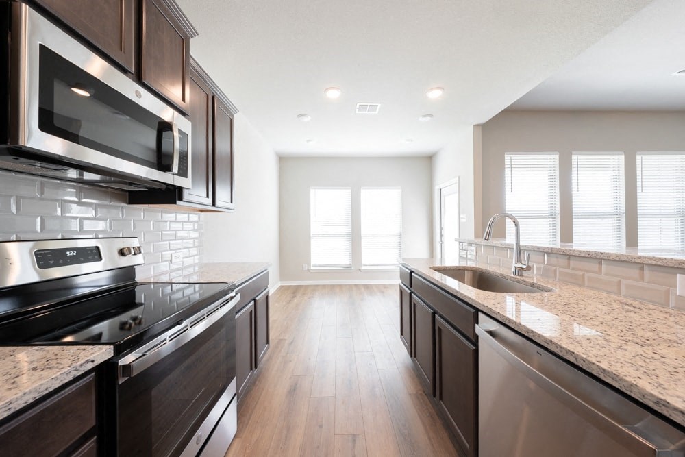 an empty kitchen with granite counter tops and stainless steel appliances